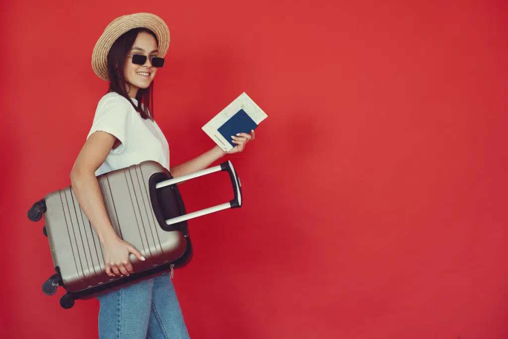 woman with suitcase and british passport in hand